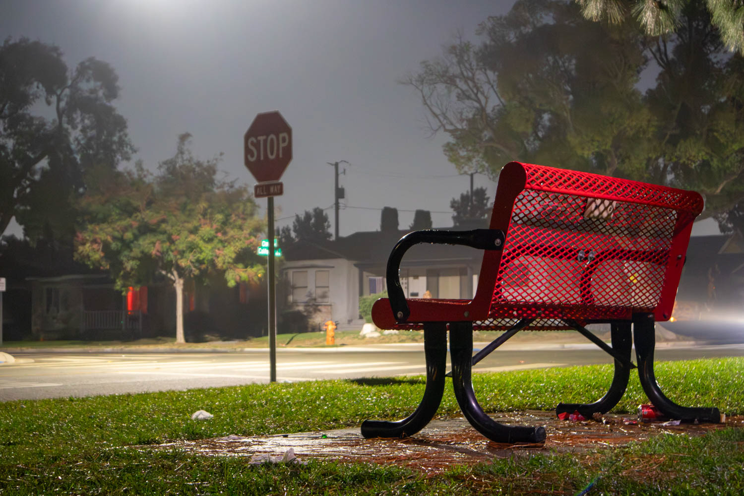 Red bench on a foggy night under streetlight